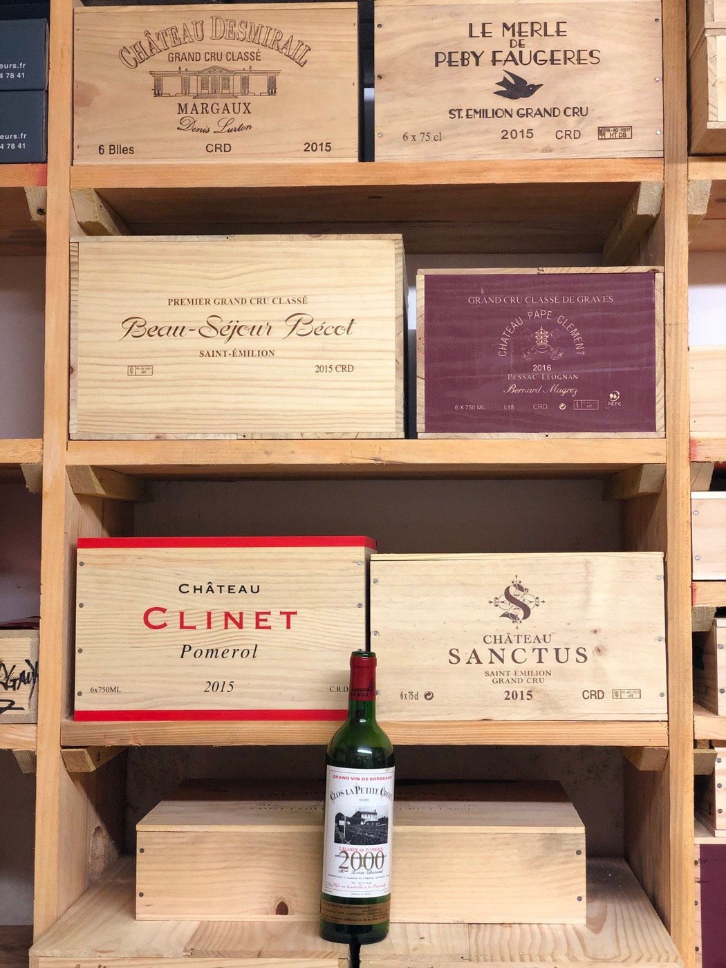 Wooden cases of Grand Cru Classé wines stacked on shelves