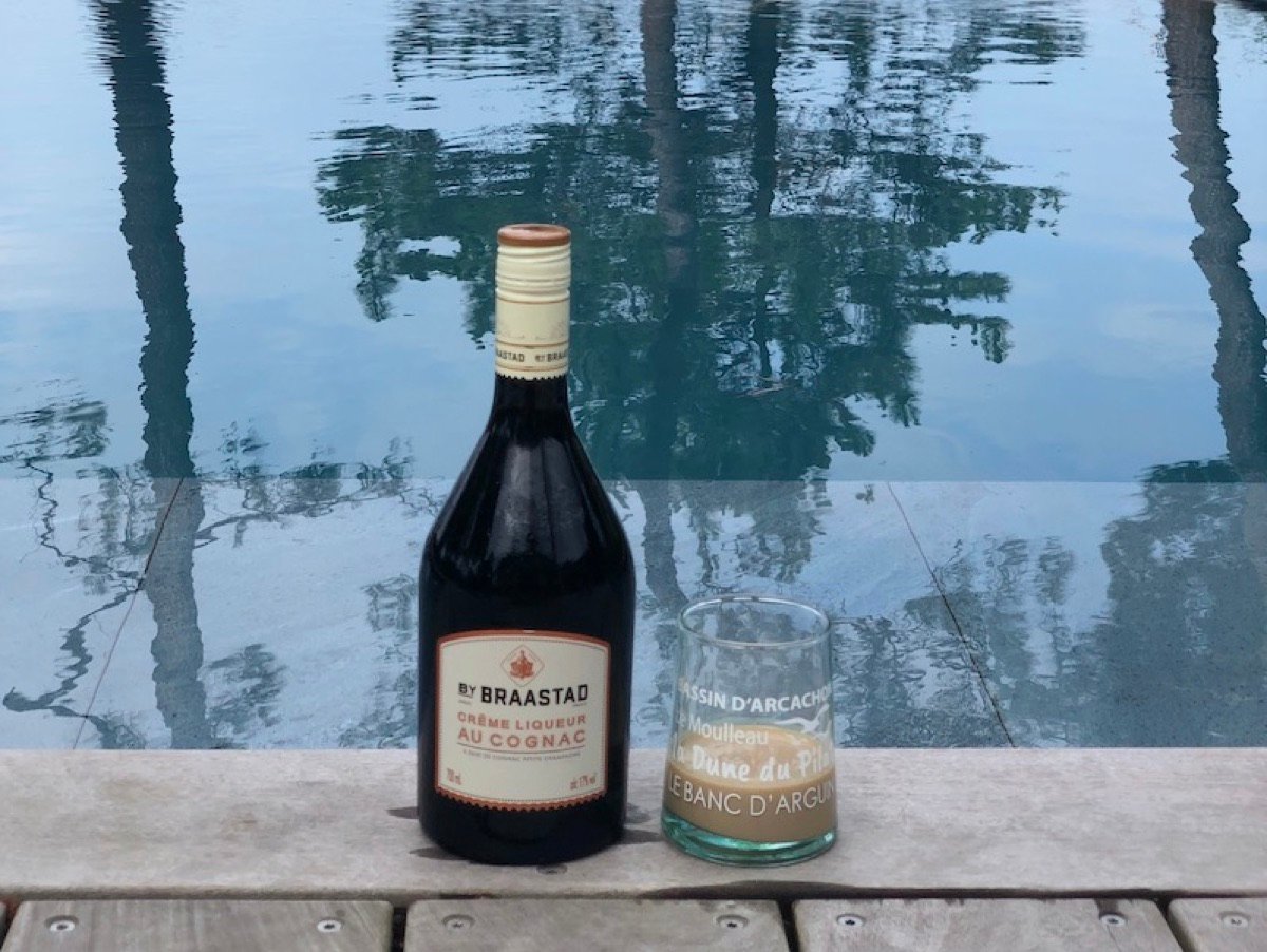 A bottle of cognac cream liqueur by a pool