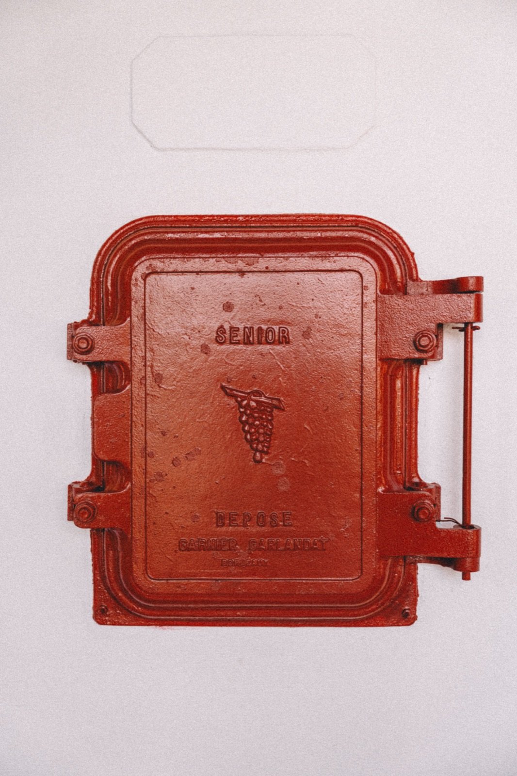 The red door of an old concrete vat