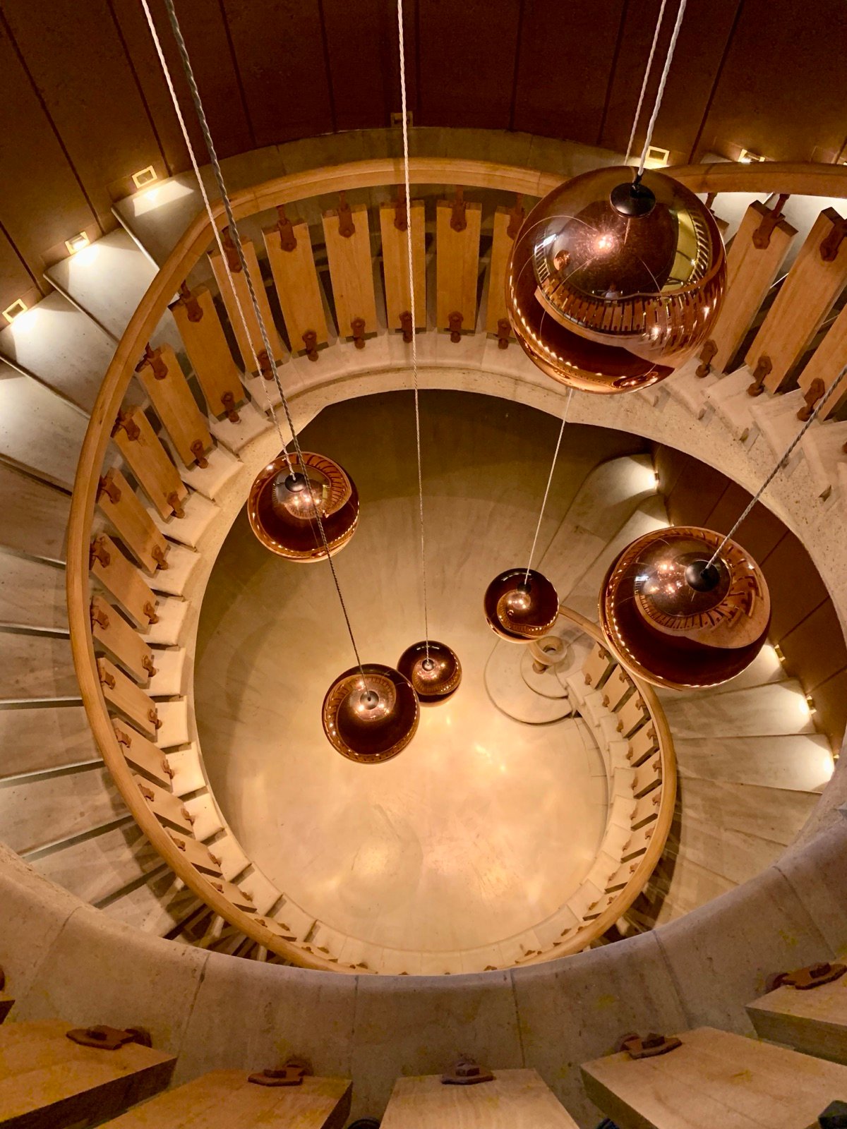 The spiral staircase and copper lights of a Sauternes château