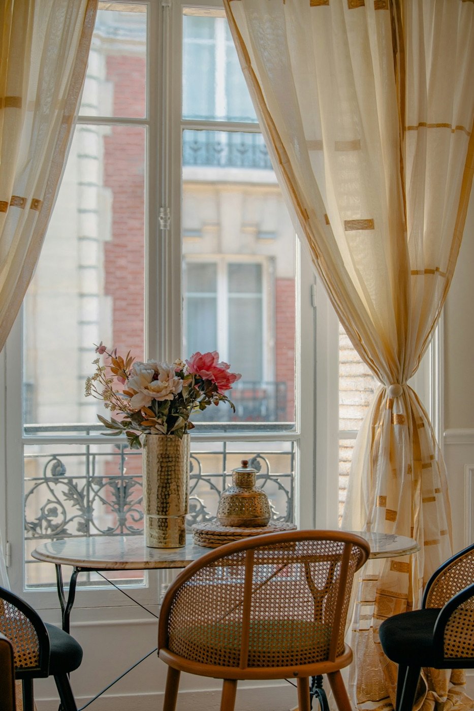 A tall window with flowers on a table