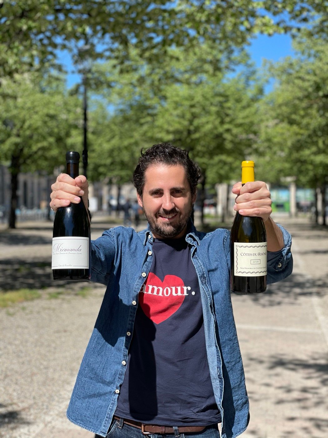 Gildas Reynaud holding two bottles of Bordeaux