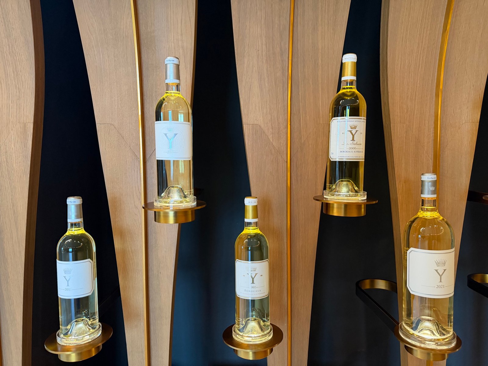 Bottles of Château d’Yquem displayed on golden stands